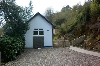 a white garage with a window and a fence at Highland Snug in Dunoon