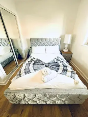 a bedroom with a large bed with towels on it at 2 Bed Entire Upper Cottage Flat in Central Glasgow in Glasgow