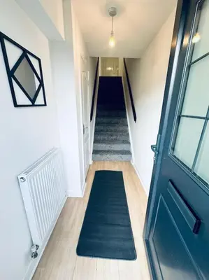 a hallway with a blue door and a staircase at 2 Bed Entire Upper Cottage Flat in Central Glasgow in Glasgow
