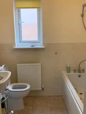 a bathroom with a toilet and a sink and a window at Holytown Homes in Holytown