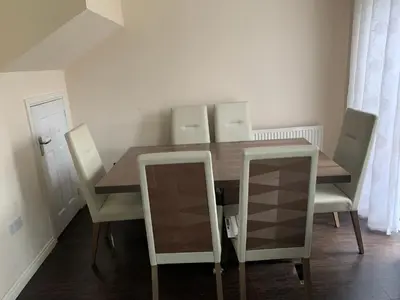 a dining room with a wooden table and chairs at Holytown Homes in Holytown