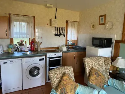 a kitchen with a washer and a stove top oven at Cottage-IsleofMull-StunningViews-WiFi-Parking in Bunessan