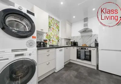a kitchen with a washing machine and a washer at Fraser House by Klass Living Rutherglen in Glasgow