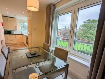 a living room with a glass table and a window at Parkgate 2 bed, private parking, Rosyth M90 in Rosyth