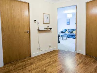 a hallway with a door and a living room at Parkgate 2 bed, private parking, Rosyth M90 in Rosyth