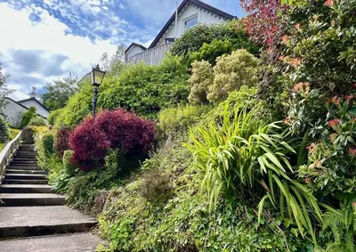 a house on a hill with flowers and plants at St Abbs in Innellan