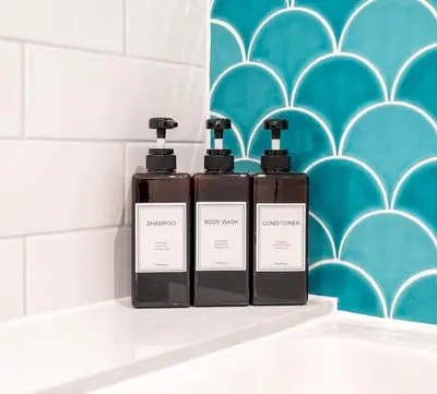 two bottles ofodorizers sitting on a shelf in a bathroom at Cottage with Hot Tub near Knockhill in Saline