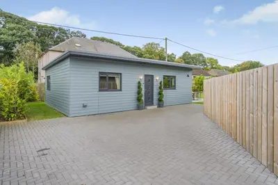 a small house with a fence in front of it at Cottage with Hot Tub near Knockhill in Saline