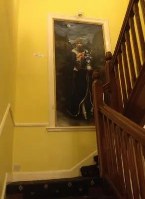 a painting of a man with a camera on a wall at Twin Lions Hotel in Edinburgh