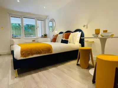 a bedroom with a large bed with a yellow blanket at Designer Studio in Edinburgh with Free Parking in Edinburgh