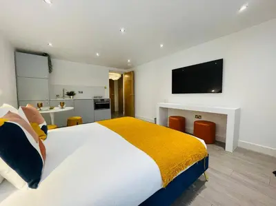 a bedroom with a large bed with a tv on the wall at Designer Studio in Edinburgh with Free Parking in Edinburgh
