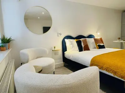 a bedroom with a bed and a mirror and a chair at Designer Studio in Edinburgh with Free Parking in Edinburgh