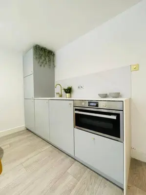 a kitchen with white cabinets and an oven at Designer Studio in Edinburgh with Free Parking in Edinburgh
