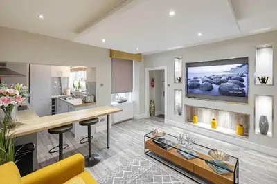a living room with a television on a wall at Craignish Apartments in Falkirk