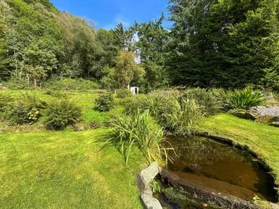 a garden with a pond in the grass at Oak -Apartment 4 in Aberfoyle