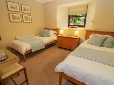 a bedroom with two beds and a window at The Barn at Daldorch in Mauchline