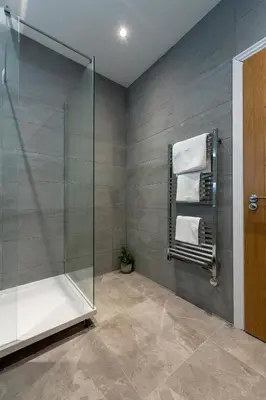 a bathroom with a shower and a glass shower stall at The Hazlitt Apartments in Paisley