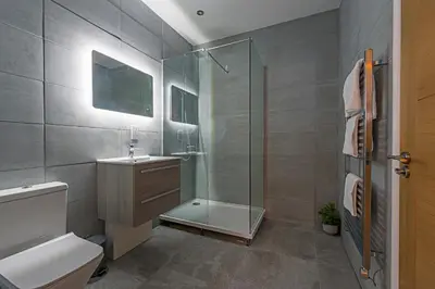 a bathroom with a shower and a toilet and a sink at The Hazlitt Apartments in Paisley