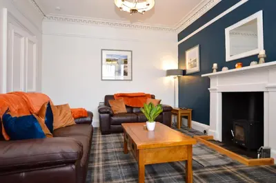 a living room with a couch and a fireplace at Crossaig Farm House in Crossaig