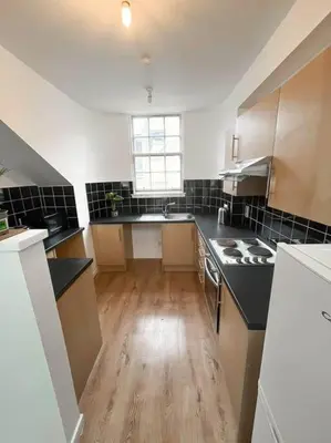 a kitchen with black and white appliances and a wooden floor at Edinburgh elms for 4 - New Town - City Center EB8 in Edinburgh
