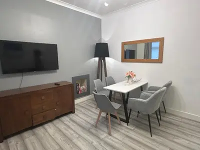 a living room with a table and chairs and a television at 2B apartment near Glasgow SEC, OVO Hydro & city centre in Glasgow