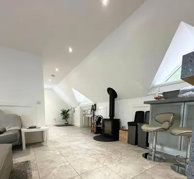 a living room with a couch and a fireplace at The Orchard Apartment, Clyde Valley in Dalserf