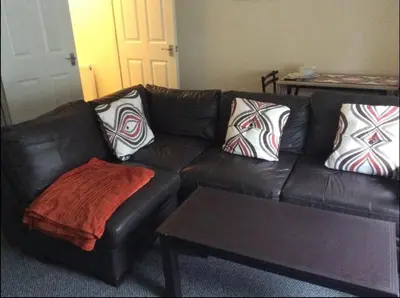 a brown leather couch with pillows and a coffee table at 103 NELSON STREET Aubery in Largs