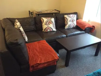 a living room with a leather couch and a coffee table at 103 NELSON STREET Aubery in Largs