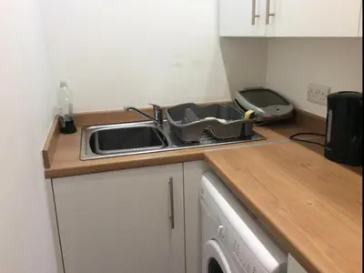 a kitchen counter with a sink and a washing machine at 103 NELSON STREET Aubery in Largs