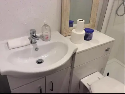 a bathroom with a sink and a mirror and a toilet at 103 NELSON STREET Aubery in Largs