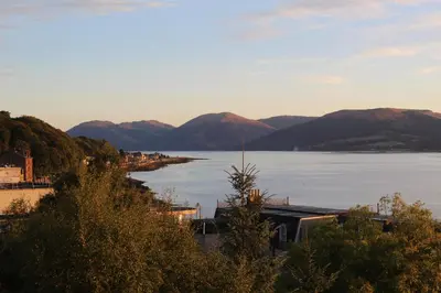 a view of a large body of water with mountains at Ghillie's Croft Cabin, Rothesay in Rothesay