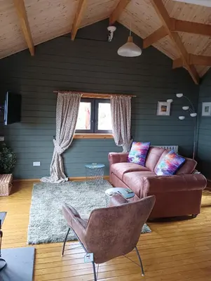 a living room with a couch and a window at Ghillie's Croft Cabin, Rothesay in Rothesay