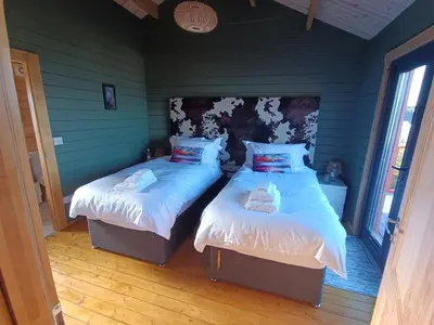 two beds in a room with green walls at Ghillie's Croft Cabin, Rothesay in Rothesay