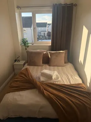 a bed in a bedroom with a window at Black Daisy in Glasgow