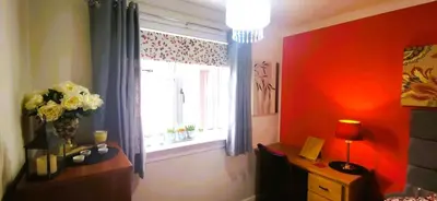 a room with a window and a desk with a vase of flowers at Double room in riverside apartment in Glasgow
