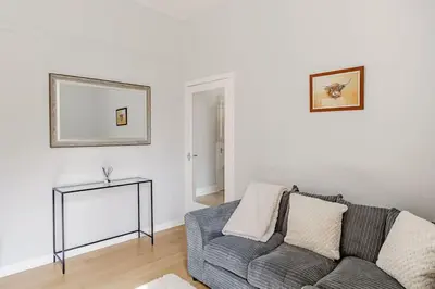 a living room with a couch and a picture on the wall at Spacious City Apt - Dunfermline in Fife