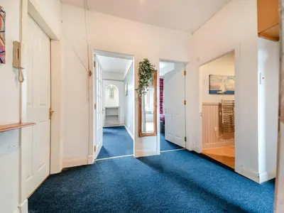 an empty hallway with blue carpet and white walls at Bay View in Oban