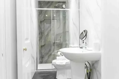a white bathroom with a toilet and a sink at Braelochan Stay in Balloch
