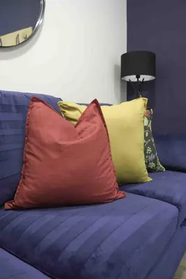 a blue couch with a red pillow on it at Braelochan Stay in Balloch