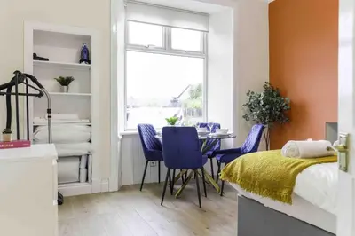 a bedroom with a bed and a table and chairs at Braelochan Stay in Balloch