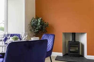 a dining room with a table and a fireplace at Braelochan Stay in Balloch