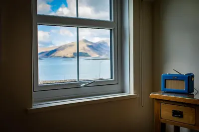 a window with a small blue tv on a table at The Pierhouse Hotel in Port Appin