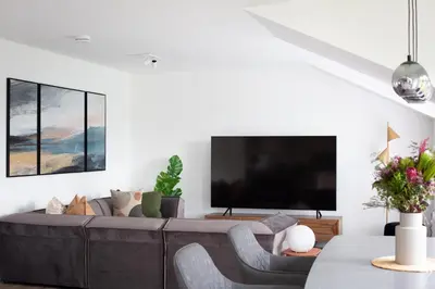 a living room with a large couch and a flat screen tv at Penthouse Apartment at Loch Lomond with 2 bedrooms in Balloch