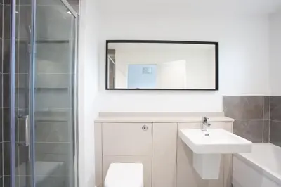 a white bathroom with a sink and a mirror at Penthouse Apartment at Loch Lomond with 2 bedrooms in Balloch