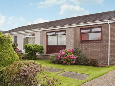 a brick house with flowers in the yard at Wallace View in Stirling