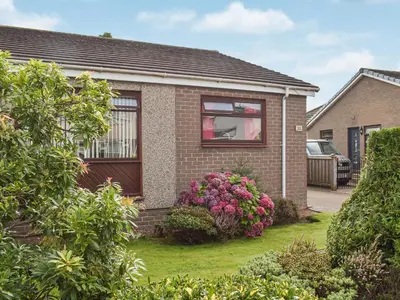 a house with a window and flowers in the yard at Wallace View in Stirling
