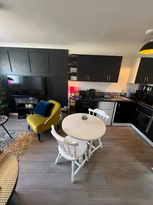 a living room with a table and a yellow couch at Elro House Holiday Let in Tillicoultry