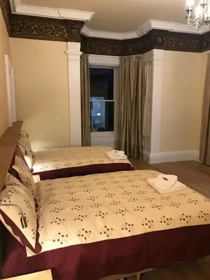 a bedroom with two beds and a window at Cumberland Hotel in Edinburgh