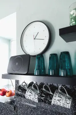 a clock sitting on top of a shelf with glasses at Carvetii - Meg's Studio - 1st Floor, Dunfermline City Centre in Dunfermline