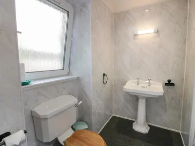 a bathroom with a white toilet and a sink at West Morton House in Thornhill